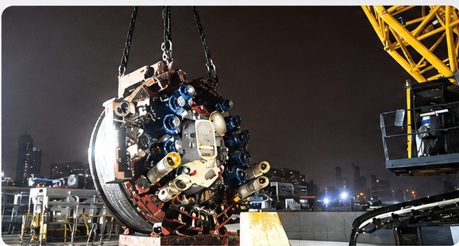 Slurry shield TBM cutterhead lifted into the launch shaft at night, Wuhan Metro Line 11 Phase IV